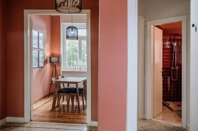 a hallway with a table and a dining room with pink walls at Rouge in Athens