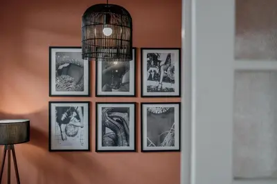 a group of framed pictures on a wall at Rouge in Athens