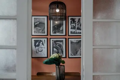 a vase on a table with pictures on a wall at Rouge in Athens