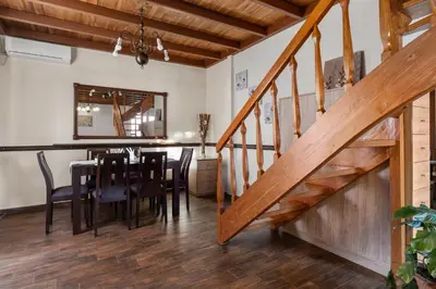 a dining room with a table and chairs and a staircase at Angi&George house in Athens