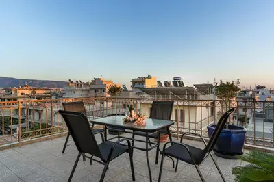 a patio with a table and chairs on a balcony at Angi&George house in Athens