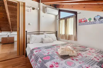 a bedroom with a bed with a blanket and a window at Angi&George house in Athens