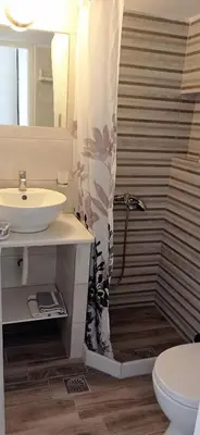 a bathroom with a sink and a shower curtain at Sunrise Flora in Agia Marina Aegina