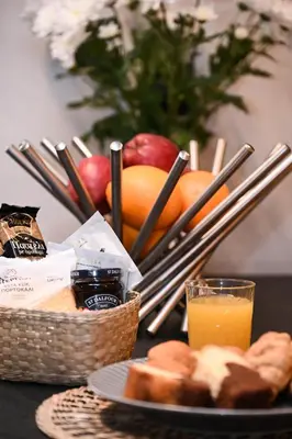 a table with a basket of bread and a glass of orange juice at Cocoon Athenian Riviera by Neuvel in Athens