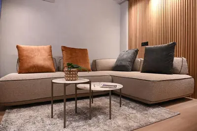 a living room with a couch and a table at Cocoon Athenian Riviera by Neuvel in Athens