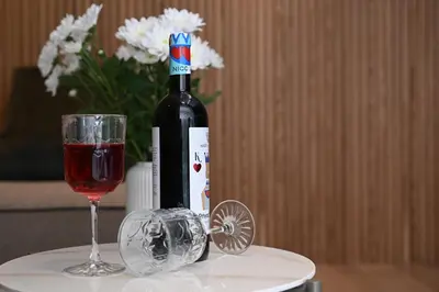 a bottle of wine and a glass on a table at Cocoon Athenian Riviera by Neuvel in Athens