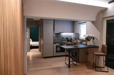 a kitchen with a table in the middle of a room at Cocoon Athenian Riviera by Neuvel in Athens