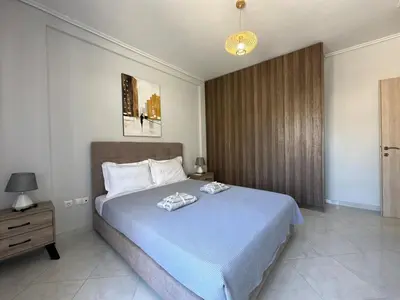 a bedroom with a large bed with a blue blanket at Redamancy -- PERI009 in Athens
