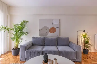 a living room with a couch and two potted plants at Large 2Bedroom, 2Bathroom Flat with Dining Space & Free Parking in Athens