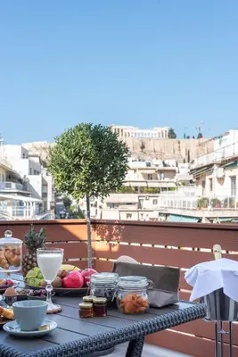 a table with food and drinks on a balcony at Acropolis Divine Apartments in Athens