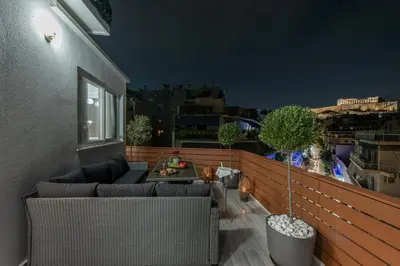 a balcony with a couch and a table on a building at Acropolis Divine Apartments in Athens