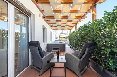 a porch with chairs and a table with a tv on it at Acropolis Divine Apartments in Athens
