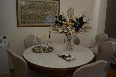 a dining room table with a vase of flowers and candles at Classy apt. Sokratous in Athens
