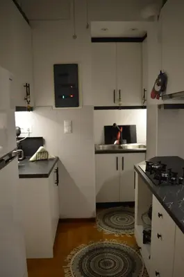 a kitchen with white cabinets and black counter tops at Classy apt. Sokratous in Athens