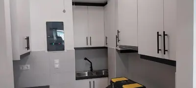 a kitchen with white cabinets and a sink at Classy apt. Sokratous in Athens