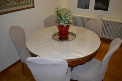 a white table with a vase with flowers on it at Classy apt. Sokratous in Athens