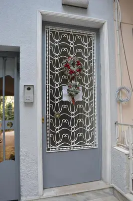 a door with a gate with a flower arrangement on it at Classy apt. Sokratous in Athens