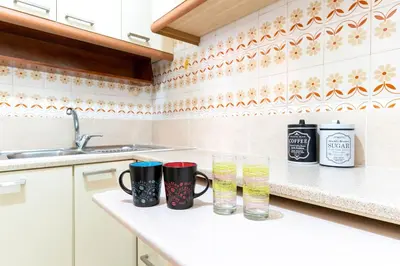 a kitchen with two mugs and glasses on a counter at Maria's Apartment δίπλα στο Νοσοκομείο Παίδων και στο Λαϊκό in Athens