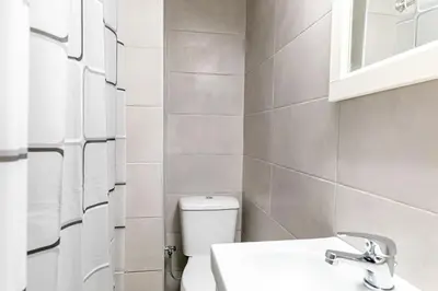 a white bathroom with a toilet and a sink at Maria's Apartment δίπλα στο Νοσοκομείο Παίδων και στο Λαϊκό in Athens