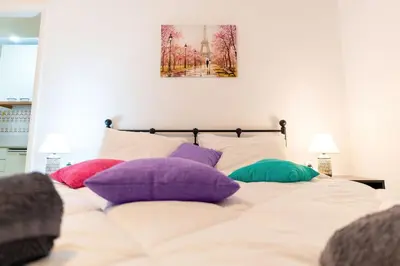 a bed with colorful pillows on top of it at Maria's Apartment δίπλα στο Νοσοκομείο Παίδων και στο Λαϊκό in Athens