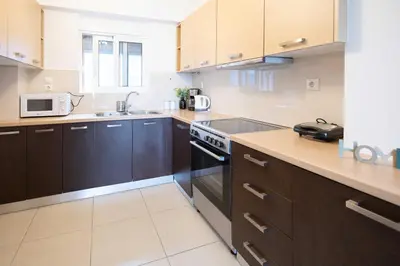 a kitchen with wooden cabinets and a stove top oven at Waylink Residences - Piraeus Port DRB in Piraeus