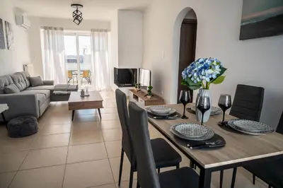 a living room with a table with chairs and a couch at Waylink Residences - Piraeus Port DRB in Piraeus