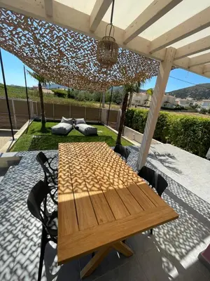 a wooden table and chairs under a pergola at GS-Vibes in Porto Rafti