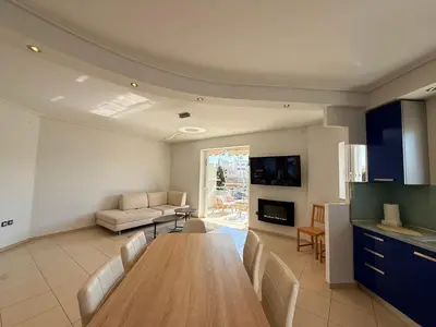 a living room with a table and a couch at Sunny Home Private Jacuzzi Hydromassage, Fireplace, Acropolis & Lycabettus View, Underground Parking, 300m Metro Peristeri in Athens