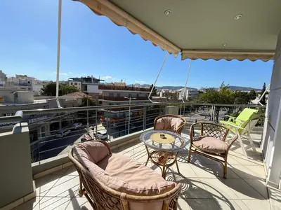 a balcony with chairs and a table on a ship at Sunny Home Private Jacuzzi Hydromassage, Fireplace, Acropolis & Lycabettus View, Underground Parking, 300m Metro Peristeri in Athens