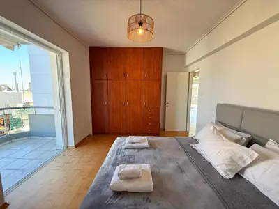 a bedroom with a large bed with two towels on it at Sunny Home Private Jacuzzi Hydromassage, Fireplace, Acropolis & Lycabettus View, Underground Parking, 300m Metro Peristeri in Athens