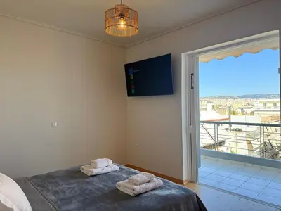 a bedroom with two towels on a bed and a window at Sunny Home Private Jacuzzi Hydromassage, Fireplace, Acropolis & Lycabettus View, Underground Parking, 300m Metro Peristeri in Athens