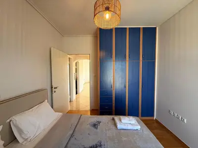 a bedroom with a large bed and a blue wall at Sunny Home Private Jacuzzi Hydromassage, Fireplace, Acropolis & Lycabettus View, Underground Parking, 300m Metro Peristeri in Athens