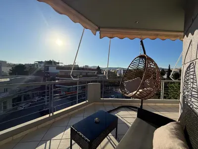 a balcony with a hammock and a swing at Sunny Home Private Jacuzzi Hydromassage, Fireplace, Acropolis & Lycabettus View, Underground Parking, 300m Metro Peristeri in Athens