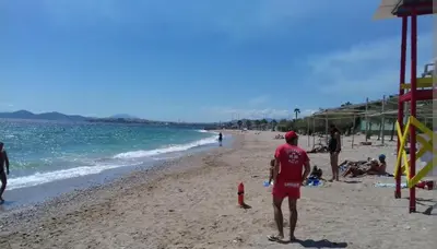 a man standing on a beach near the water at Paleo Faliro Athens fully equipped 2 bedrooms 90 sqm big apartment 200m to Free beach in Athens