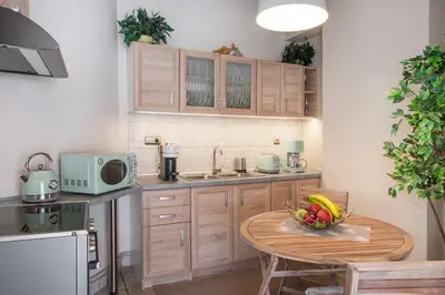 a kitchen with a table with a bowl of fruit on it at Vicky's Sky Loft in Piraeus