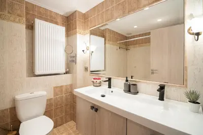 a bathroom with a toilet and a sink and a mirror at Vicky's Sky Loft in Piraeus