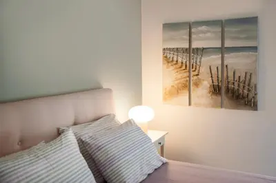 a bedroom with a bed and a painting of a pier at Vicky's Sky Loft in Piraeus