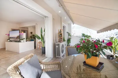 a living room with a glass table and chairs at Vicky's Sky Loft in Piraeus