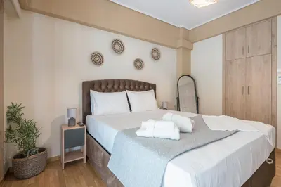 a bedroom with a large bed with two towels on it at Stylish City Apartment by CloudKeys in Athens