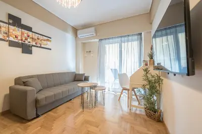 a living room with a couch and a table at Stylish City Apartment by CloudKeys in Athens