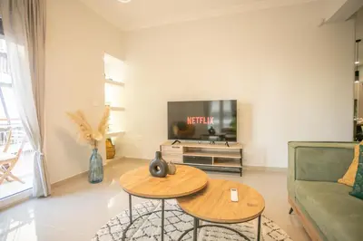a living room with two tables and a tv at Modern and Luxury apartment in Athens