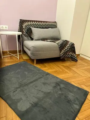 a living room with a couch and a rug at apartment Alimos near the sea in Alimos