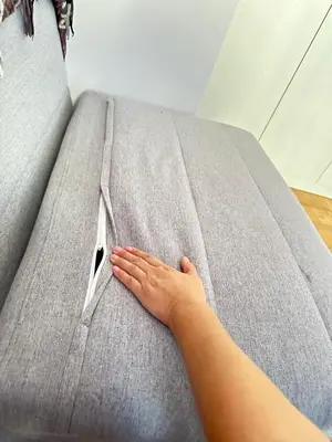 a person laying on a couch with their hand on it at apartment Alimos near the sea in Alimos