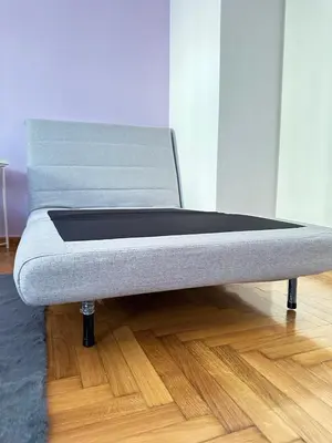 a bed sitting on top of a wooden floor at apartment Alimos near the sea in Alimos