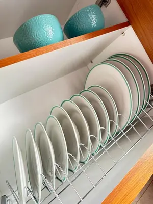 a shelf with plates and bowls on it at apartment Alimos near the sea in Alimos