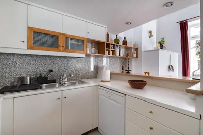a white kitchen with white cabinets and a sink at Athenian Getaway Villa in Plaka with Acropolis View by Athenian Homes in Athens