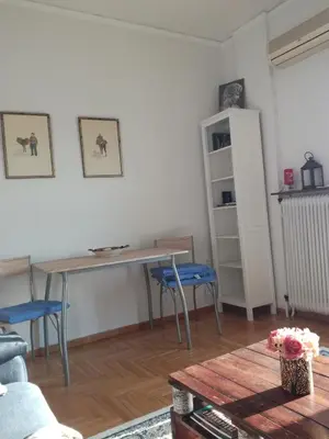 a living room with a wooden table and blue chairs at Mia's Seaside Penthouse - Panoramic View in Piraeus