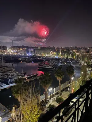 a firework display over a marina at night at Mia's Seaside Penthouse - Panoramic View in Piraeus