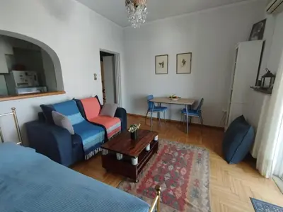 a living room with a blue couch and a table at Mia's Seaside Penthouse - Panoramic View in Piraeus