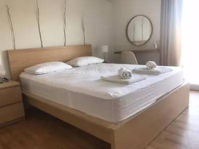 a large white bed with towels on top of it at Vasos apartment in Athens